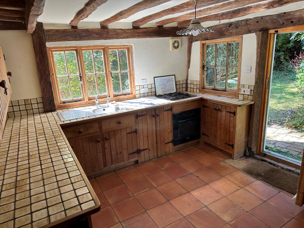 Lot: 115 - DETACHED THATCHED COTTAGE IN NEED OF REPAIR ON 1.36 ACRES OF LAND - Kitchen with access to gardens